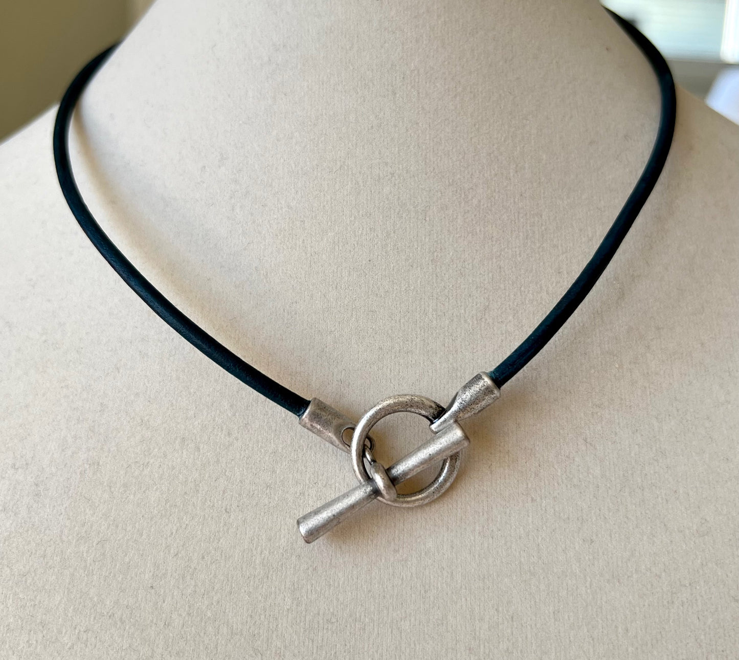 Leather Necklace Lovely black leather necklace fashioned with a trendy silver toggle clasp. To be worn in light and peace.