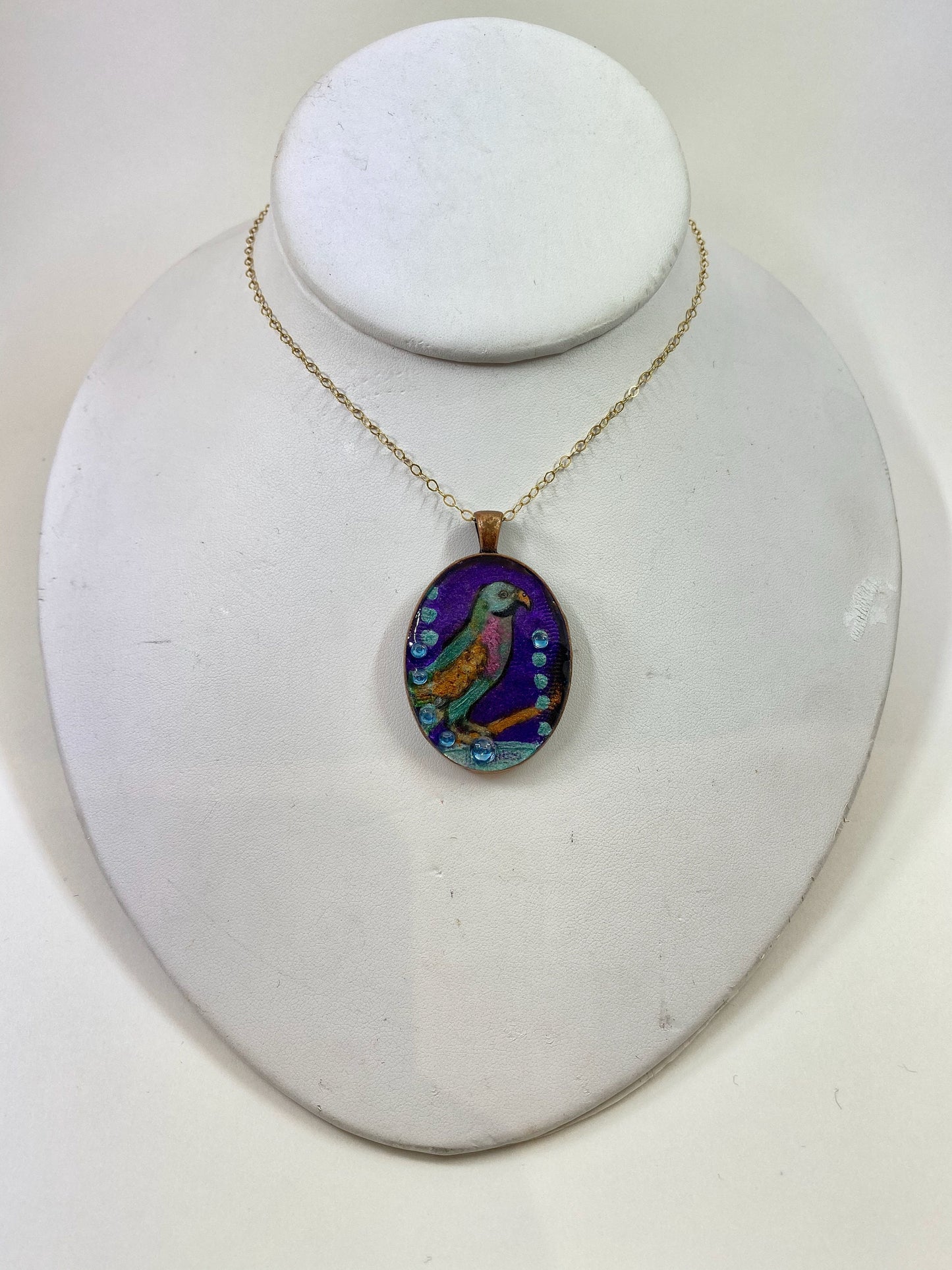 Bird and crystal pendant. Hand painted bird design with crystal accents. Brass frame and 14 karat gold filled chain.