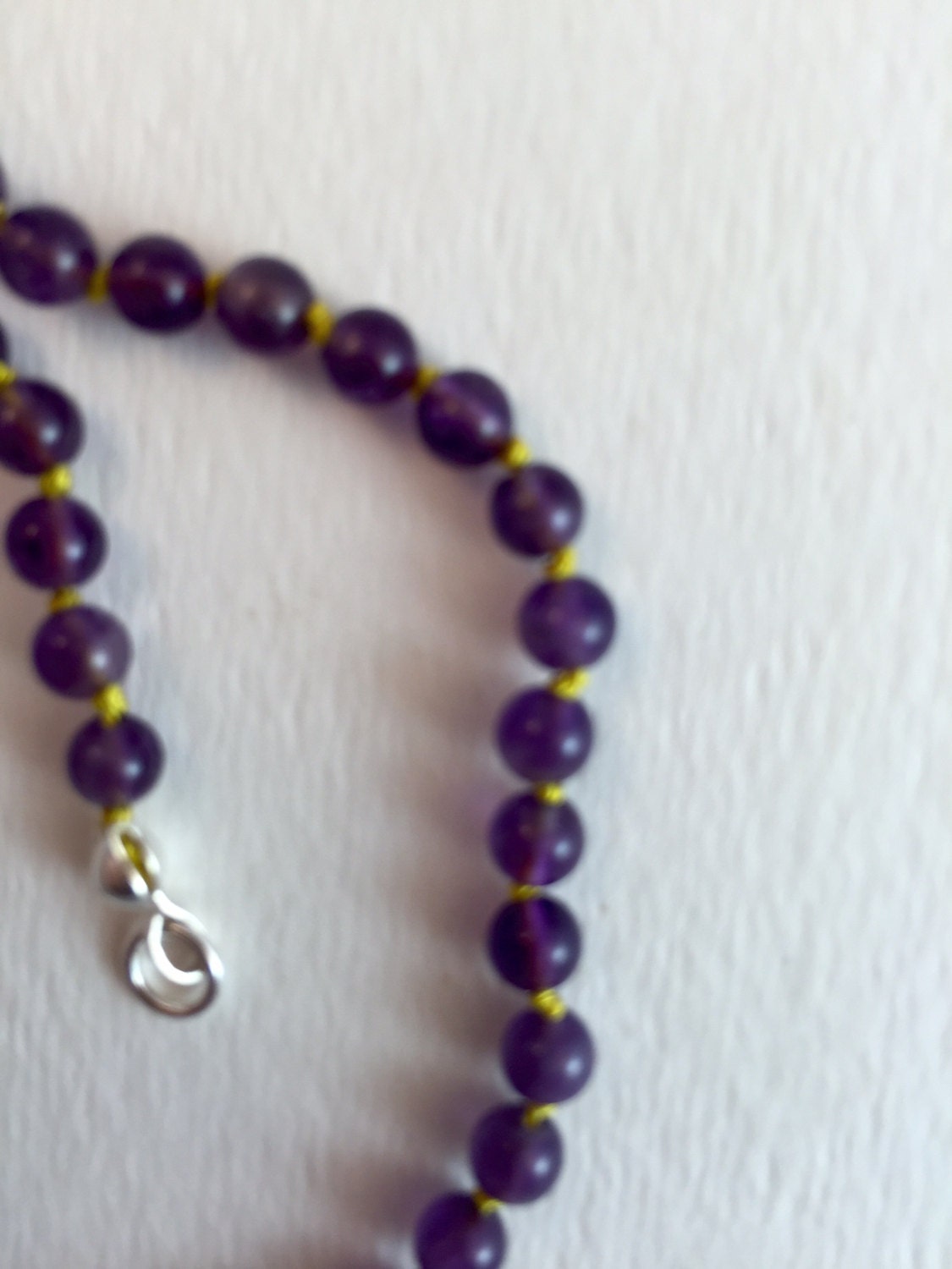 Children's treasured amethyst beaded necklace. Sweet as can be with contrasting yellow knotted thread. I measures 11 1/2 " long.