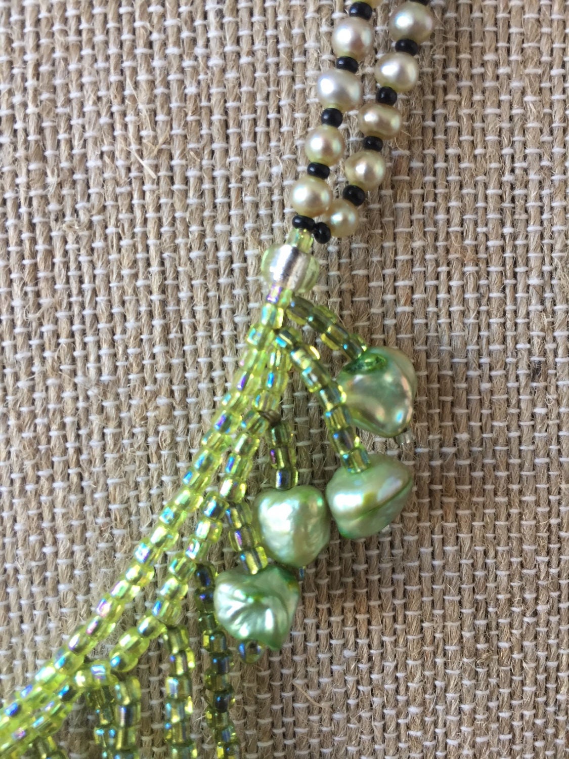 Hand woven pearl necklace. Beautiful flow with pearls and seed beads. Green and white pearls dangle on this necklace made by me in Maine.