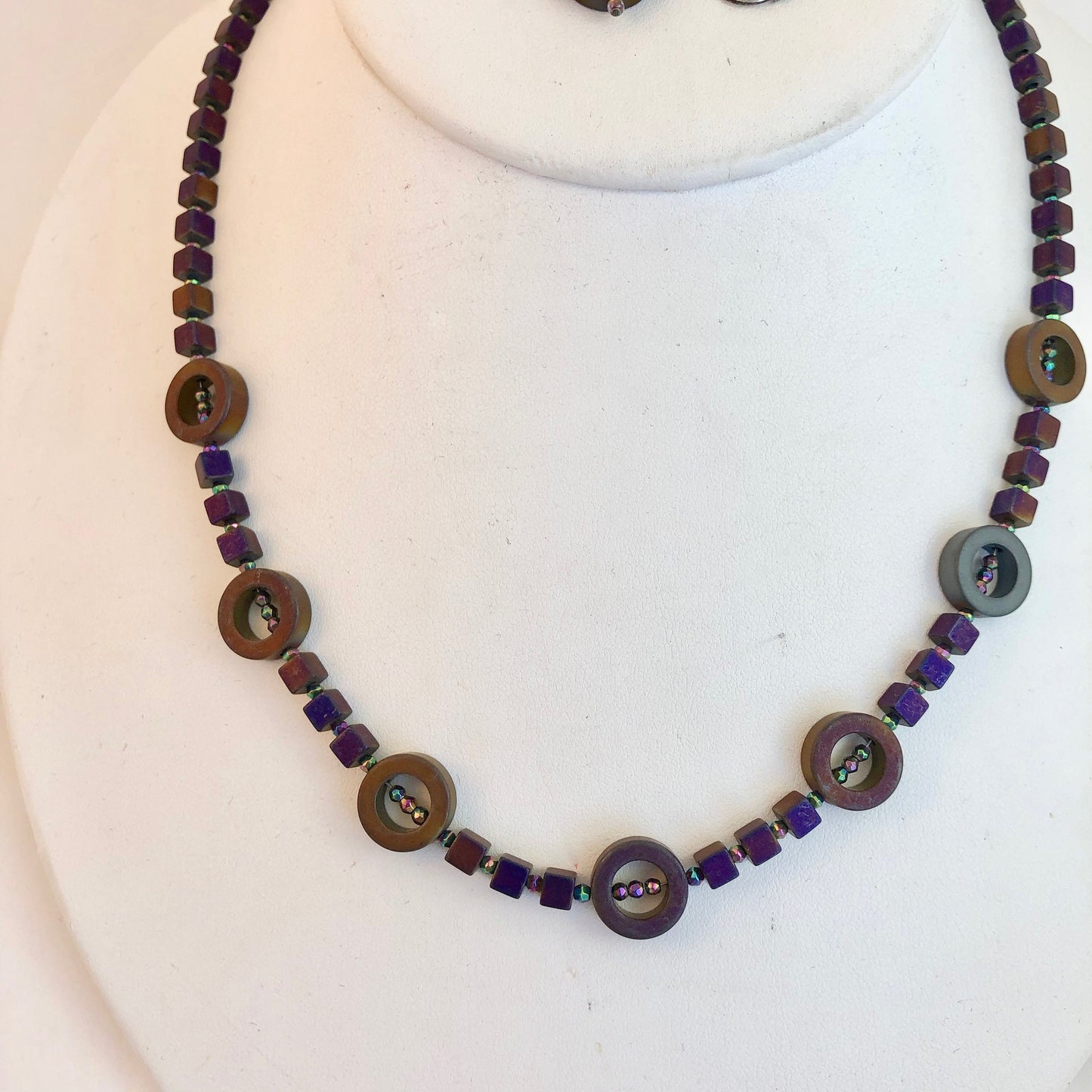 Striking and classy necklace, made of beautiful hematite stone beads. These dark purple stones, radiate with a slight aurora borealis tint.