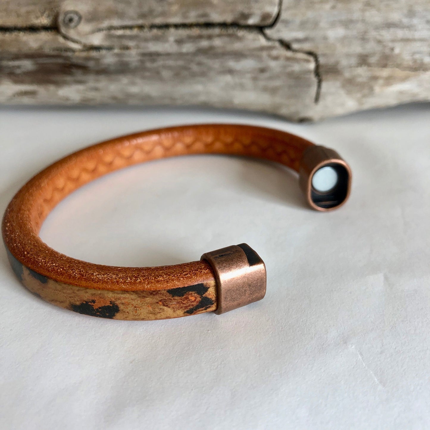 Leather bracelet, made of fine brown leopard-designed Italian licorice leather, finished with a quality copper magnetic bullet style clasp.