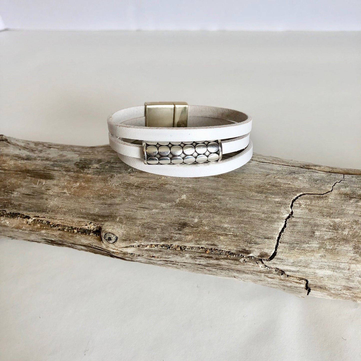 Leather bracelet, made of fine white three wrapped Italian leather, a beautiful silver slide, and finished with a quality bronze magnetic clasp.
