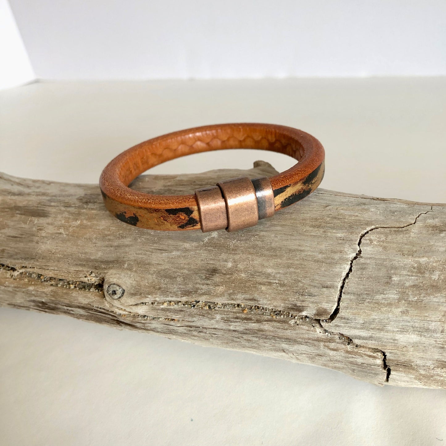 Leather bracelet, made of fine brown leopard-designed Italian licorice leather, finished with a quality copper magnetic bullet style clasp.