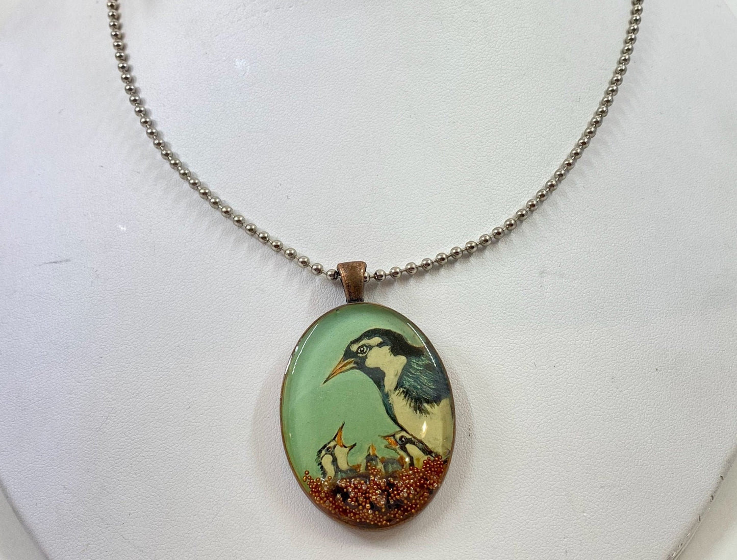 Mother bird and baby bird pendant. Hand painted bird design, accented with crystals and beads. Brass frame and 14 karat gold filled chain.