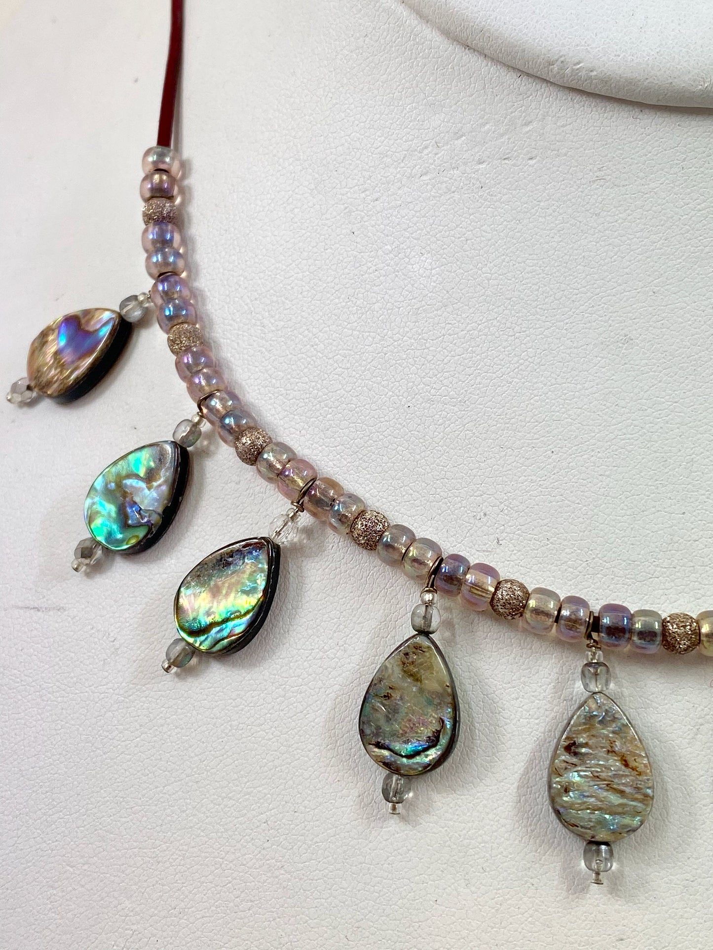 Striking abalone beaded necklace. Measures 19" long, and is finished with a quality sterling silver lobster clasp.