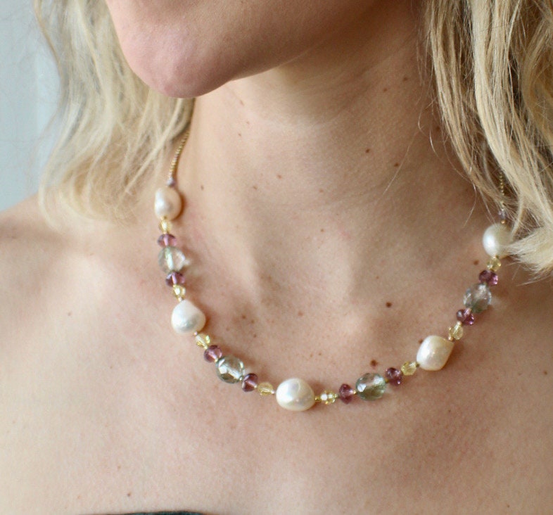 Stunning white pearl and crystal necklace. Pearls are adorned by lime, purple, gold and pale blue crystals. Finished with a sterling clasp.