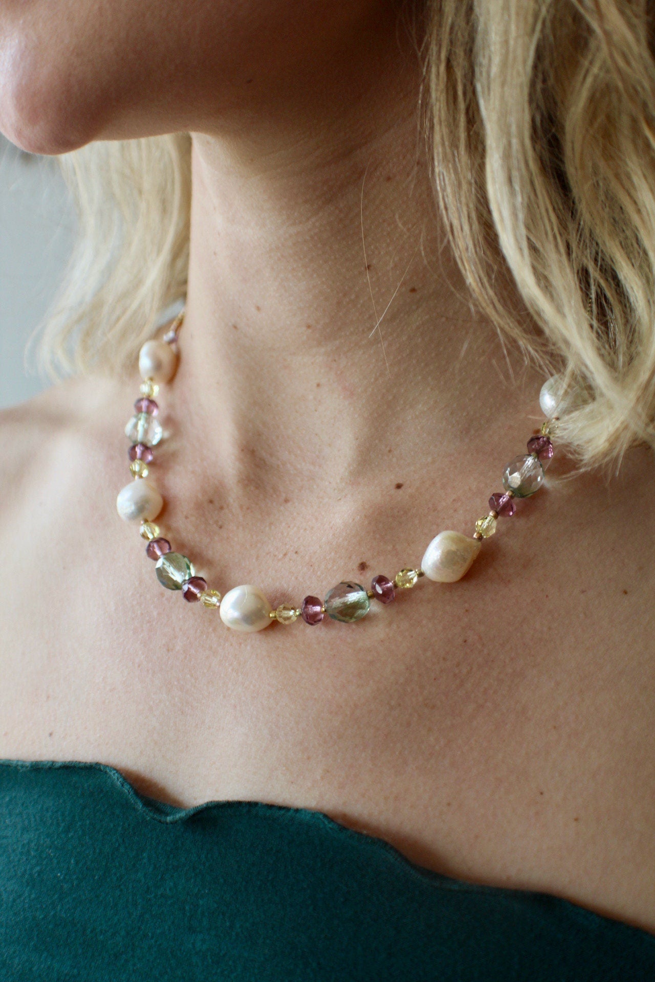 Stunning white pearl and crystal necklace. Pearls are adorned by lime, purple, gold and pale blue crystals. Finished with a sterling clasp.