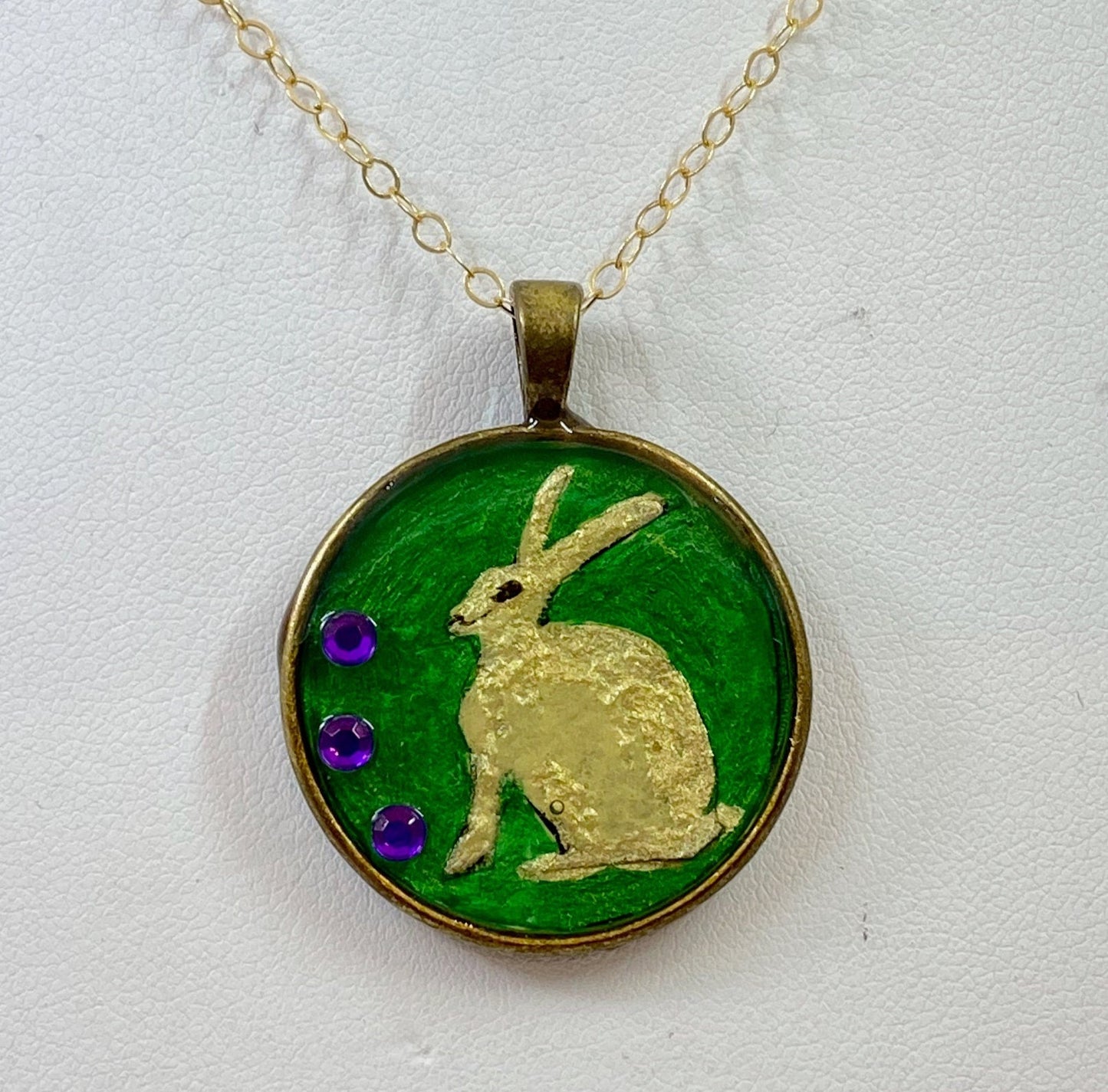 Bunny and crystal pendant. The bunny is hand painted and accented with crystal beads. Brass frame and brass chain.