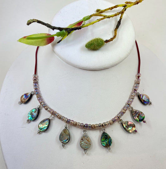 Striking abalone beaded necklace. Measures 19" long, and is finished with a quality sterling silver lobster clasp.