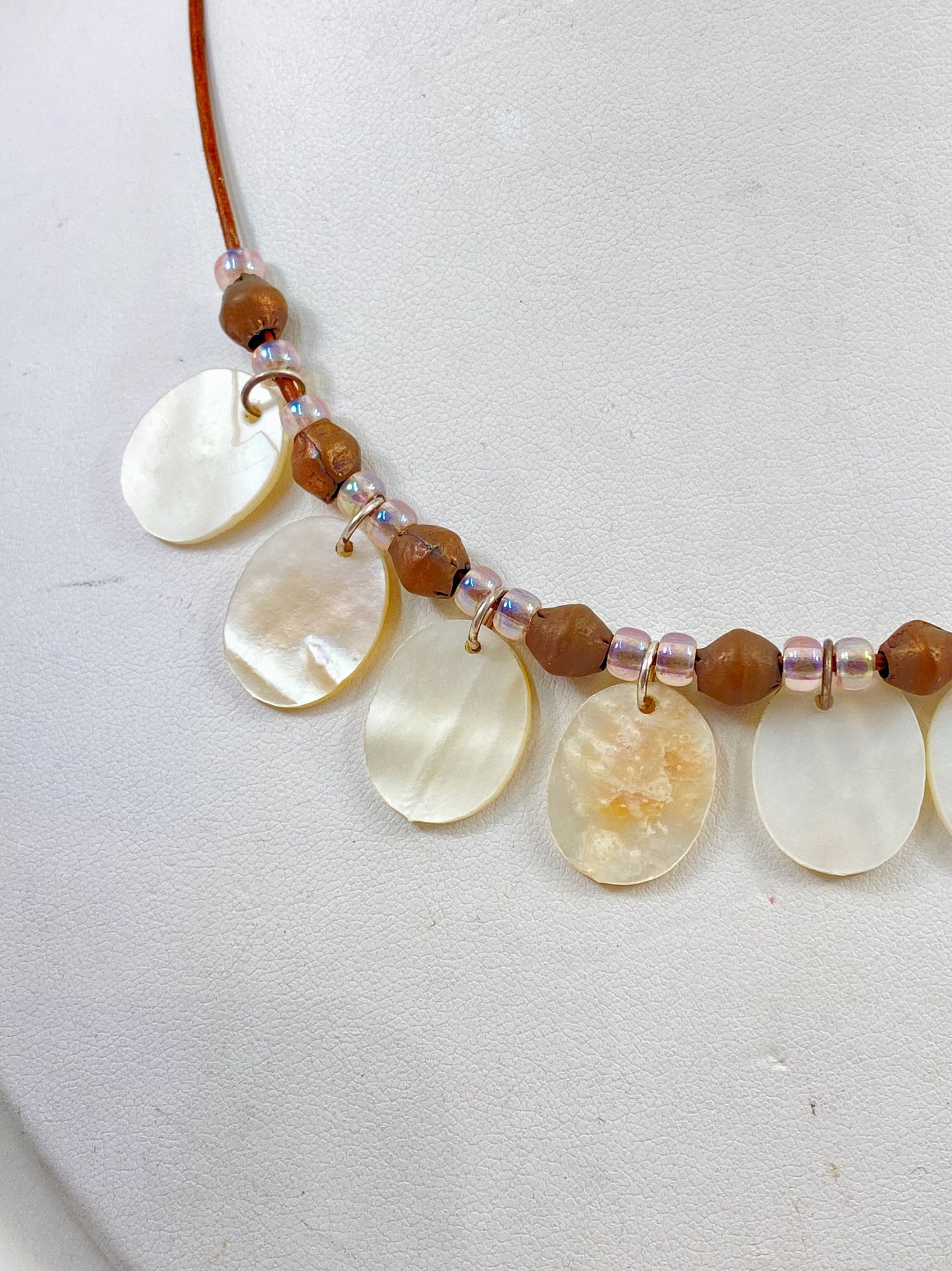 Leather Necklace. Striking Mother of Pearl and African brass prayer beads strung on soft dark brown Italian leather. Finished with a sterling silver clasp.