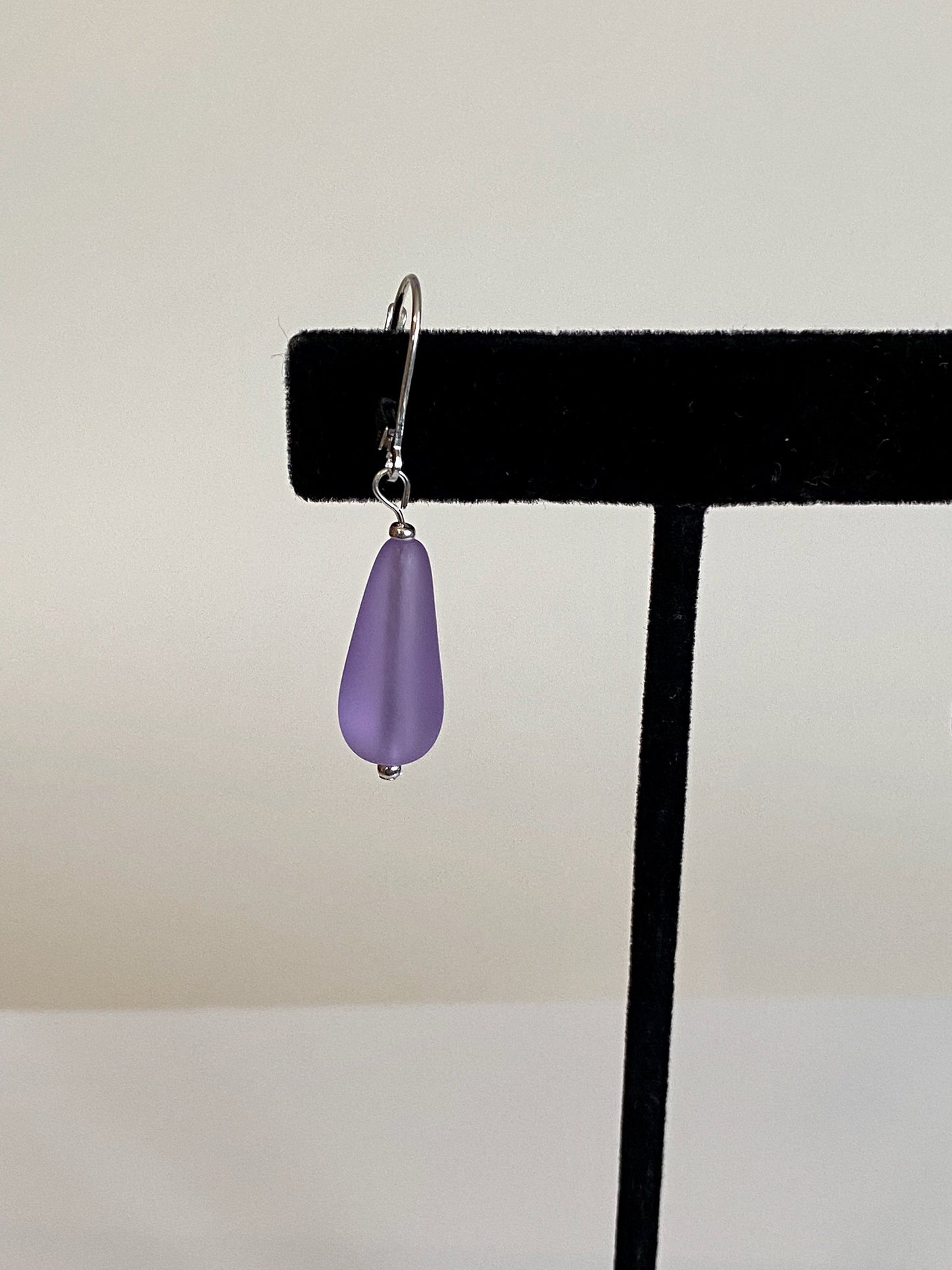 Soft sea glass type frosted purple teardrop earrings. Fashioned with a quality sterling silver lever back clasp.