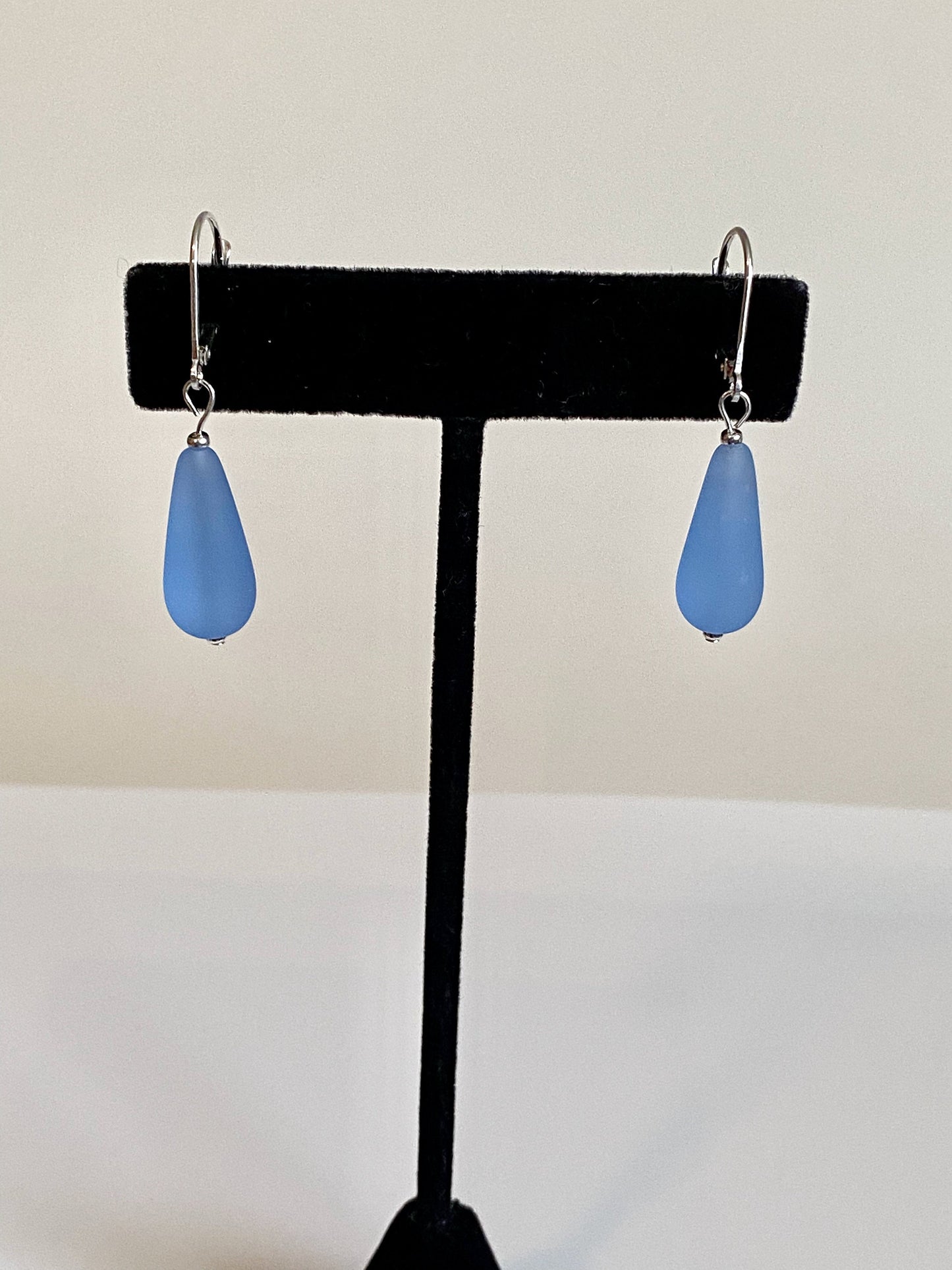 Soft sea glass type frosted sapphire blue teardrop earrings. Fashioned with a quality sterling silver lever back clasp.
