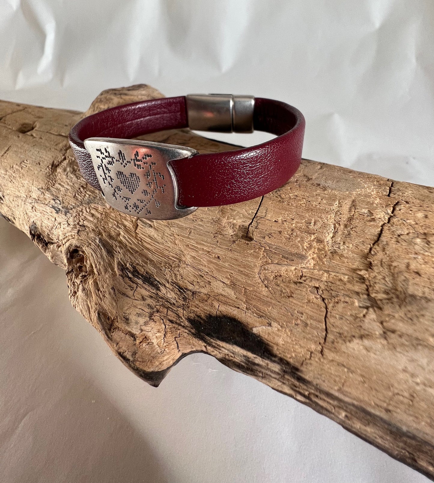 Italian rich deep red leather bracelet with heart etched silver accent piece. Closed with a silver magnetic clasp.